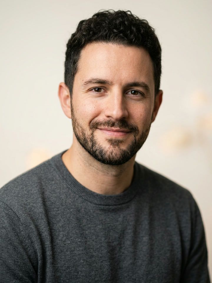 Friendly profile photo: the same man smiling in a gray sweater on a soft background