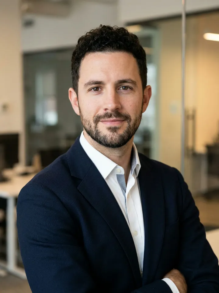 Edited: the same man in a navy blazer and white shirt in an office
